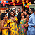 Post: The image captures a joyful indoor celebration among Black men and women, likely at a cultural event...